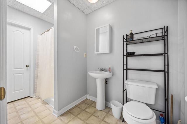 bathroom featuring sink, a paneled ceiling, a shower with shower curtain, and toilet