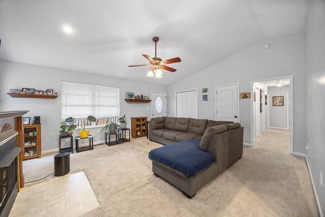 carpeted living room featuring ceiling fan and lofted ceiling