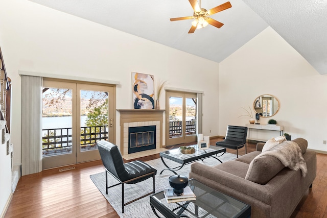 living room featuring a wealth of natural light, high vaulted ceiling, and hardwood / wood-style flooring