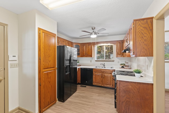 kitchen featuring ceiling fan, sink, light hardwood / wood-style flooring, a textured ceiling, and black appliances