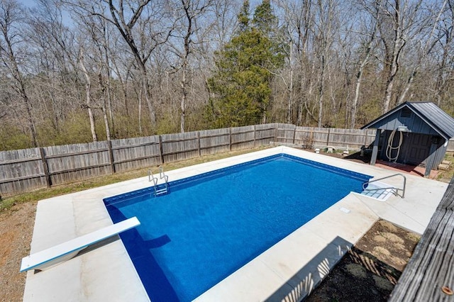 view of pool featuring an outbuilding, a fenced backyard, a shed, a fenced in pool, and a patio area