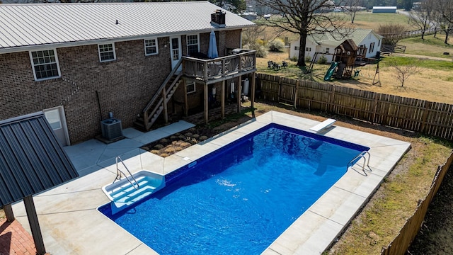 view of pool with a patio, a fenced backyard, cooling unit, a wooden deck, and stairs