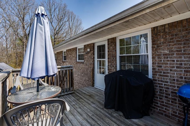 wooden deck with outdoor dining space and a grill