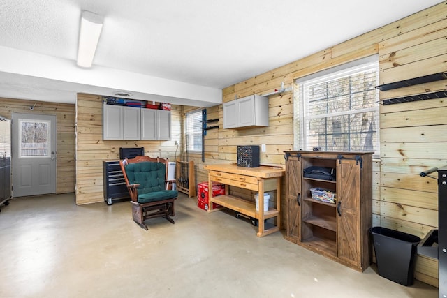 interior space featuring wooden walls and finished concrete floors