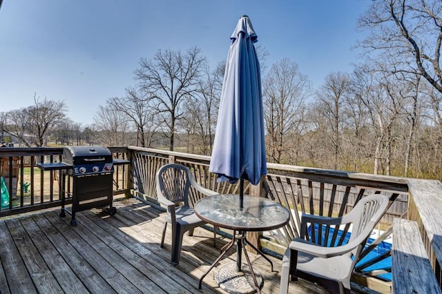 wooden deck featuring outdoor dining space and a grill