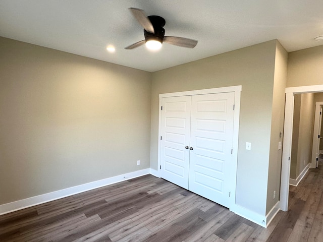 unfurnished bedroom with a closet, ceiling fan, and hardwood / wood-style flooring