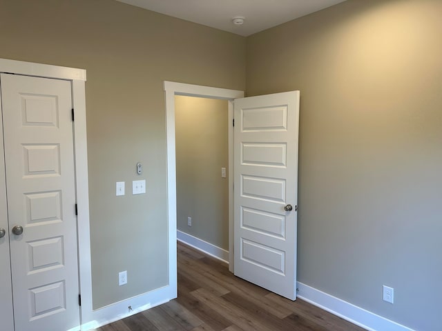 unfurnished bedroom featuring a closet and dark hardwood / wood-style flooring