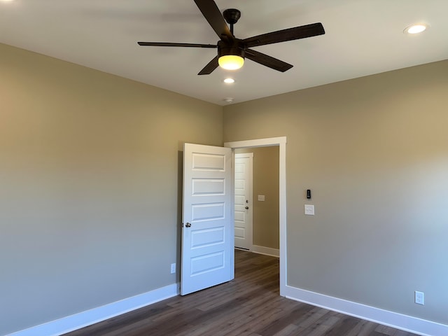 empty room featuring ceiling fan and dark hardwood / wood-style floors