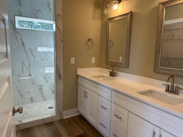 bathroom featuring hardwood / wood-style floors, vanity, and tiled shower