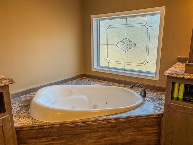 bathroom featuring a healthy amount of sunlight and a jetted tub