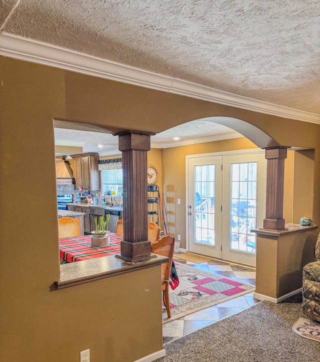 interior space featuring a healthy amount of sunlight, ornate columns, arched walkways, and ornamental molding