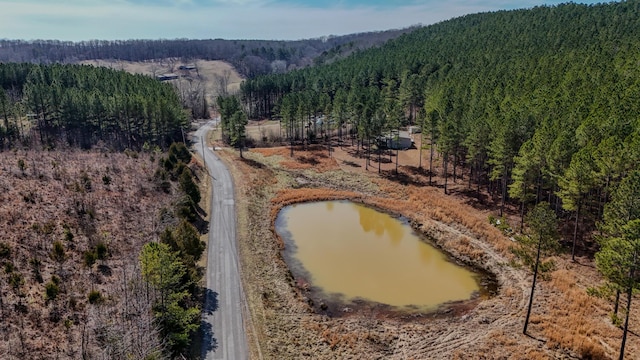 drone / aerial view with a forest view and a water view