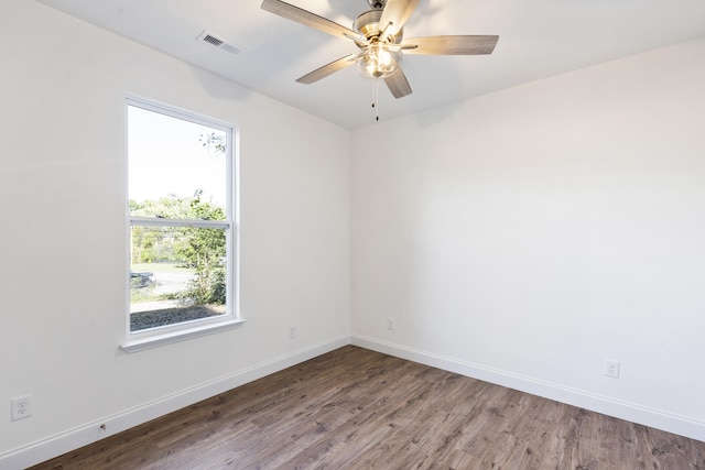 empty room with ceiling fan, a healthy amount of sunlight, and wood-type flooring