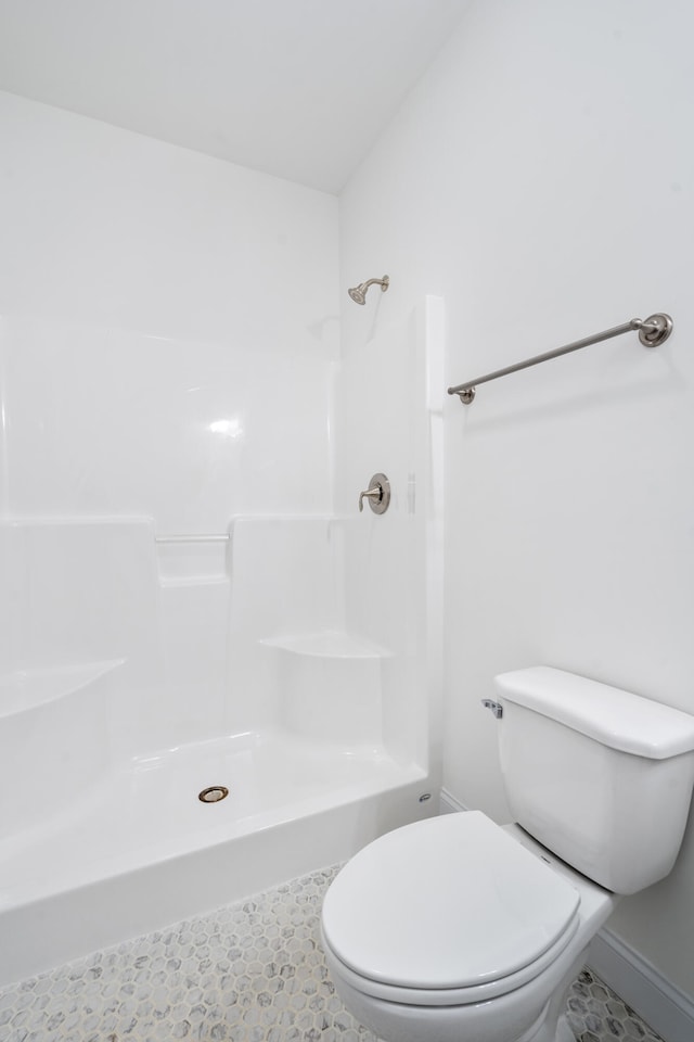 bathroom with walk in shower, tile patterned flooring, lofted ceiling, and toilet