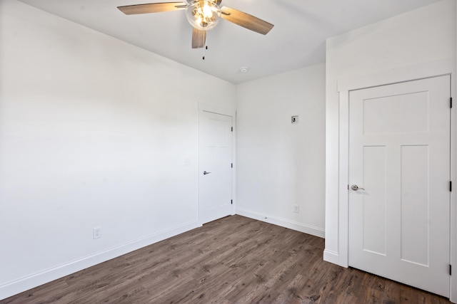 spare room with ceiling fan and dark hardwood / wood-style flooring