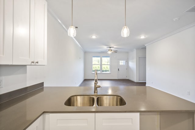 kitchen featuring ceiling fan, crown molding, sink, pendant lighting, and white cabinets