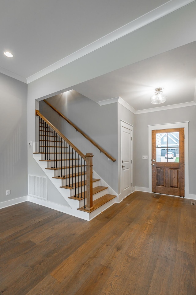 entrance foyer with dark wood-style flooring, crown molding, visible vents, stairway, and baseboards