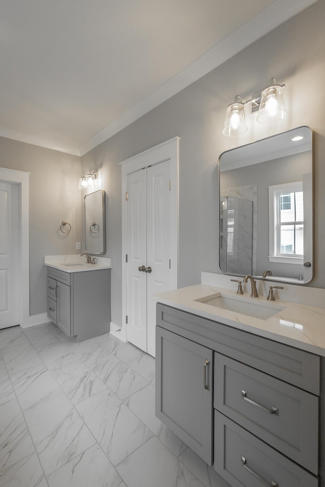 bathroom with marble finish floor, a shower stall, ornamental molding, and a sink