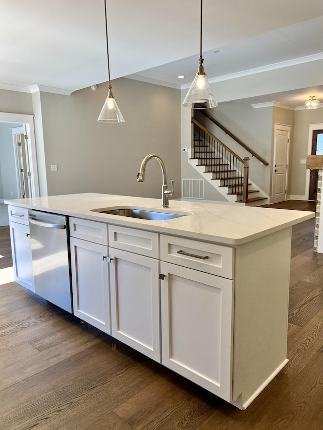 kitchen featuring light stone counters, hanging light fixtures, white cabinetry, a sink, and dishwasher