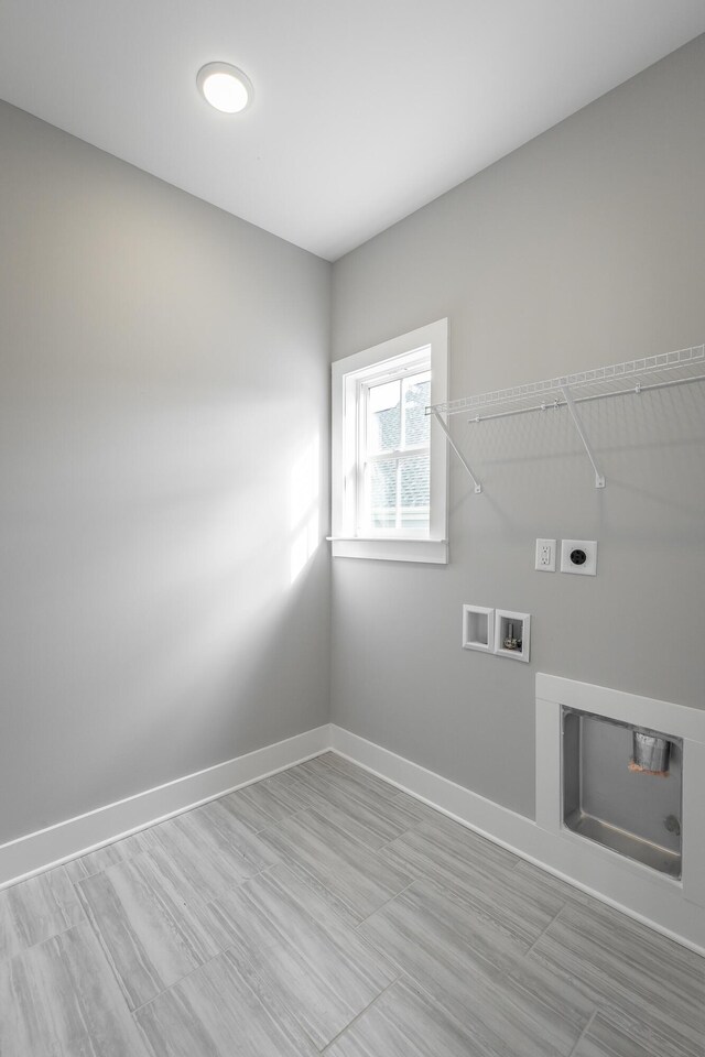 clothes washing area featuring hookup for a washing machine, laundry area, electric dryer hookup, and baseboards