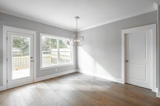 unfurnished dining area with an inviting chandelier, visible vents, wood finished floors, and ornamental molding