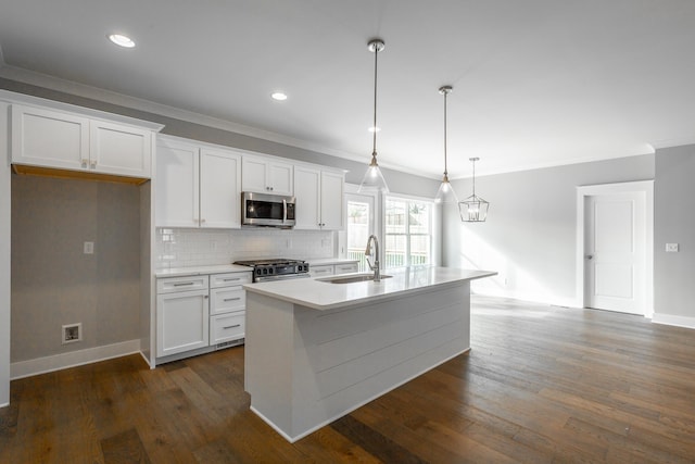 kitchen featuring a kitchen island with sink, stainless steel appliances, a sink, white cabinets, and light countertops