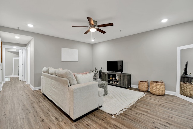 living room with ceiling fan and light wood-type flooring