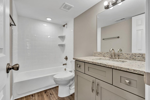 full bathroom with hardwood / wood-style floors, vanity, toilet, and tiled shower / bath