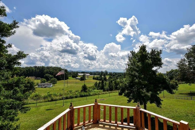 deck with a rural view and a yard