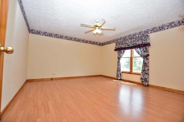 empty room featuring hardwood / wood-style flooring, ceiling fan, and a textured ceiling