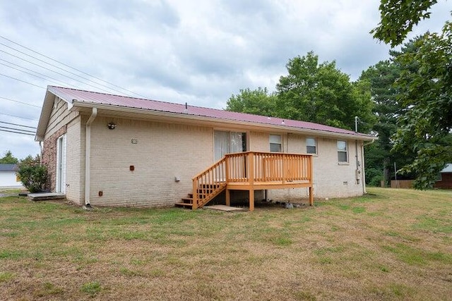 rear view of property featuring a wooden deck and a yard