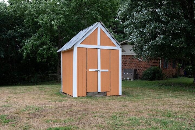 view of outbuilding featuring a yard and central AC