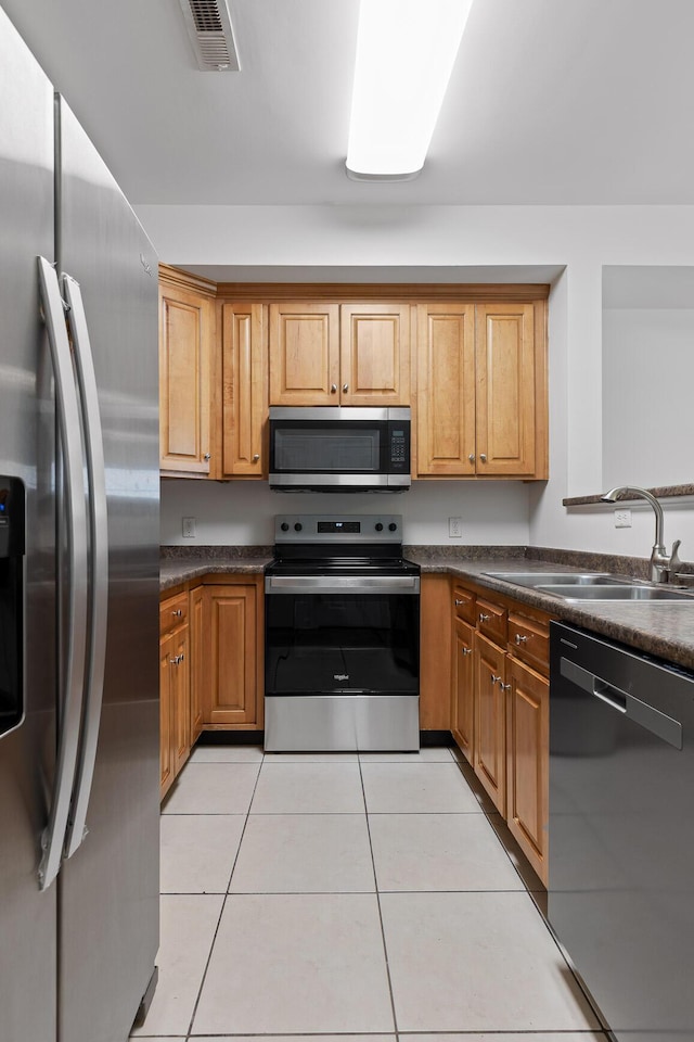 kitchen featuring stainless steel appliances, sink, and light tile patterned floors