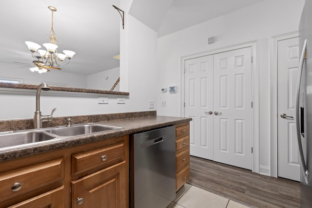 kitchen featuring decorative light fixtures, ceiling fan with notable chandelier, stainless steel dishwasher, and sink