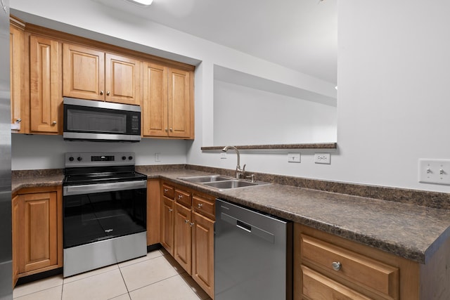 kitchen featuring appliances with stainless steel finishes, light tile patterned floors, and sink