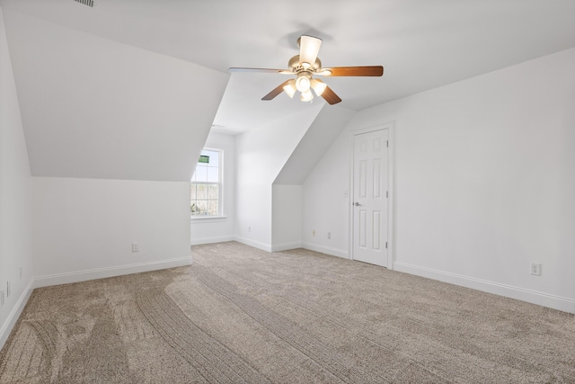 additional living space with lofted ceiling, ceiling fan, and light colored carpet