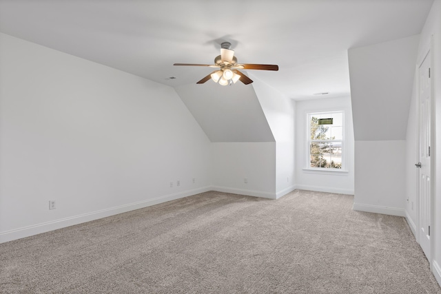 additional living space featuring vaulted ceiling, light carpet, and ceiling fan