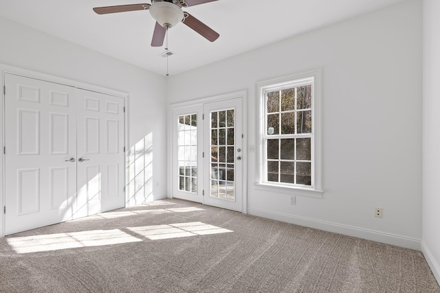 spare room with ceiling fan and light colored carpet