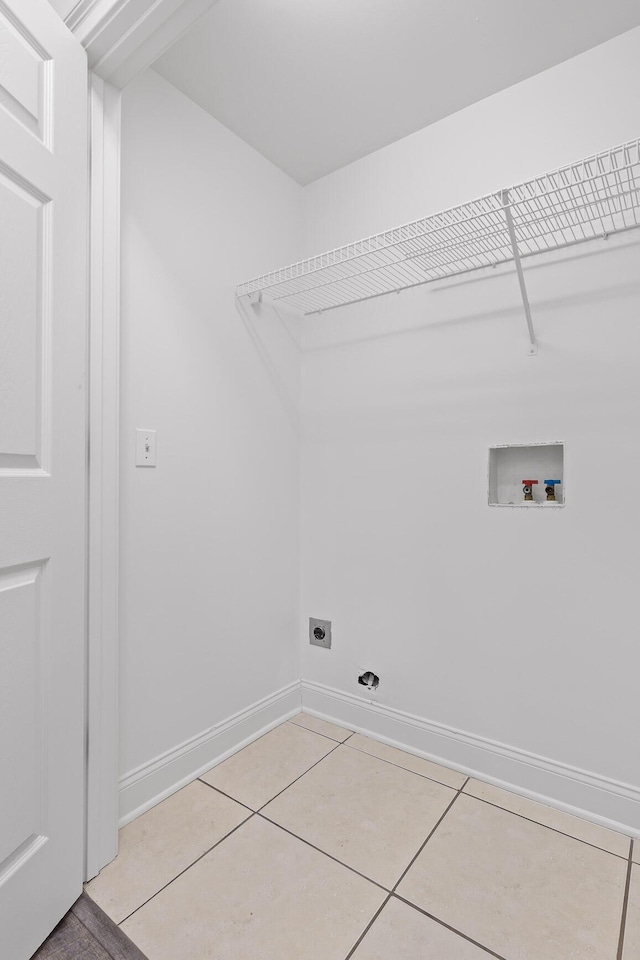 clothes washing area featuring electric dryer hookup, light tile patterned floors, and washer hookup