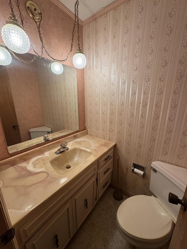 bathroom featuring toilet, ornamental molding, and vanity