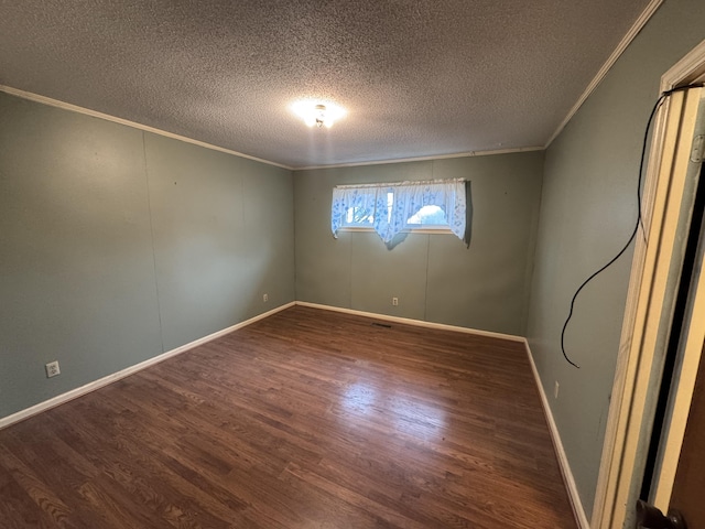 spare room featuring a textured ceiling, dark wood-type flooring, and ornamental molding