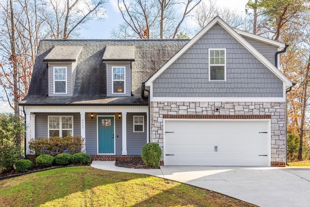 view of front of house with a porch, a garage, and a front lawn