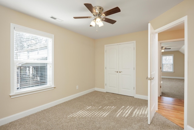 unfurnished bedroom featuring ceiling fan, a closet, carpet floors, and vaulted ceiling