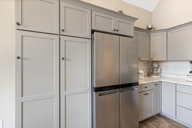 155 Surrey Ln NE, Cleveland, TN 37312 - kitchen featuring freestanding refrigerator, gray cabinets, tasteful backsplash, light wood-style floors, and light stone countertops