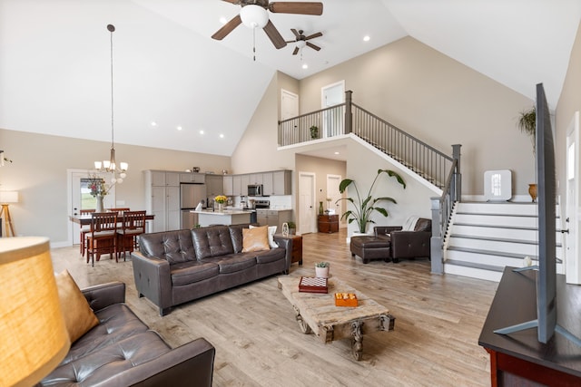 155 Surrey Ln NE, Cleveland, TN 37312 - living room with high vaulted ceiling, a ceiling fan, stairway, light wood-style flooring, and a chandelier