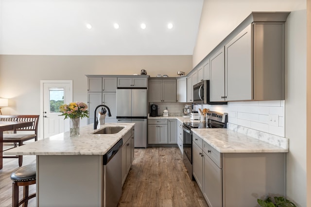155 Surrey Ln NE, Cleveland, TN 37312 - kitchen with appliances with stainless steel finishes, gray cabinetry, light stone countertops, tasteful backsplash, and wood finished floors