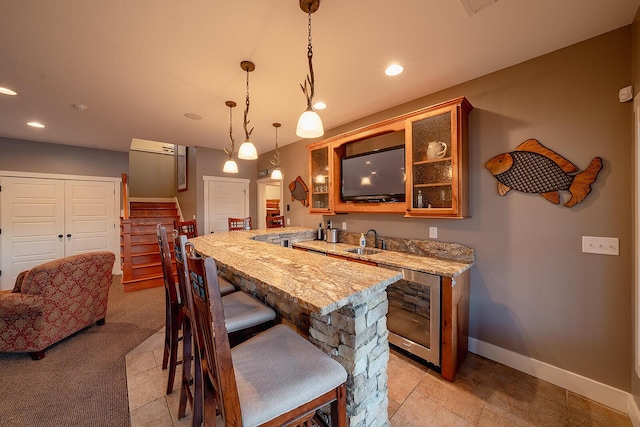 bar with pendant lighting, recessed lighting, a sink, wet bar, and baseboards