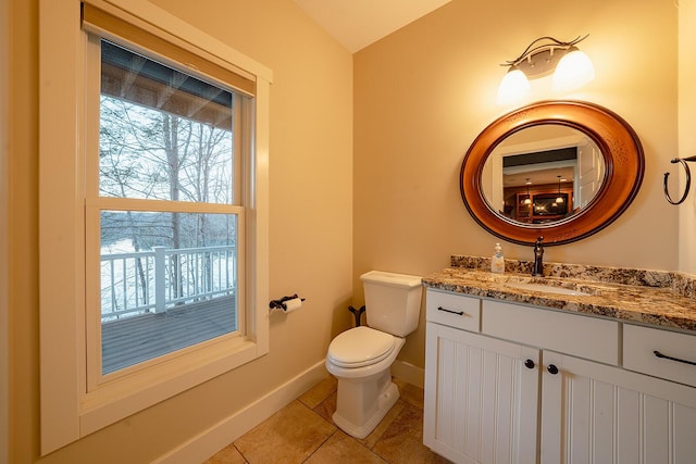 half bath with toilet, tile patterned flooring, baseboards, and vanity