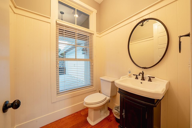 bathroom with vanity, wood finished floors, toilet, and baseboards