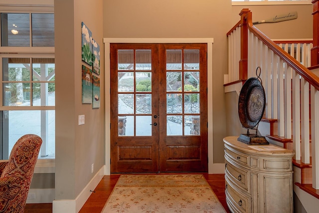 doorway featuring stairs, french doors, wood finished floors, and baseboards